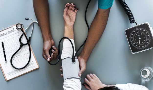 nurse measuring blood pressure after yoga for hypertension