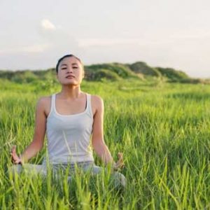 girl meditating in field